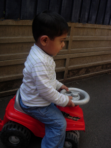 Boy playing outside on a bike at Early Learners' Nursery School, Leicester